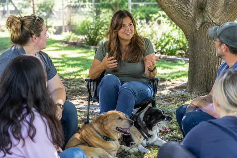 Foster volunteer sitting with a calm dog during a quiet community outreach moment